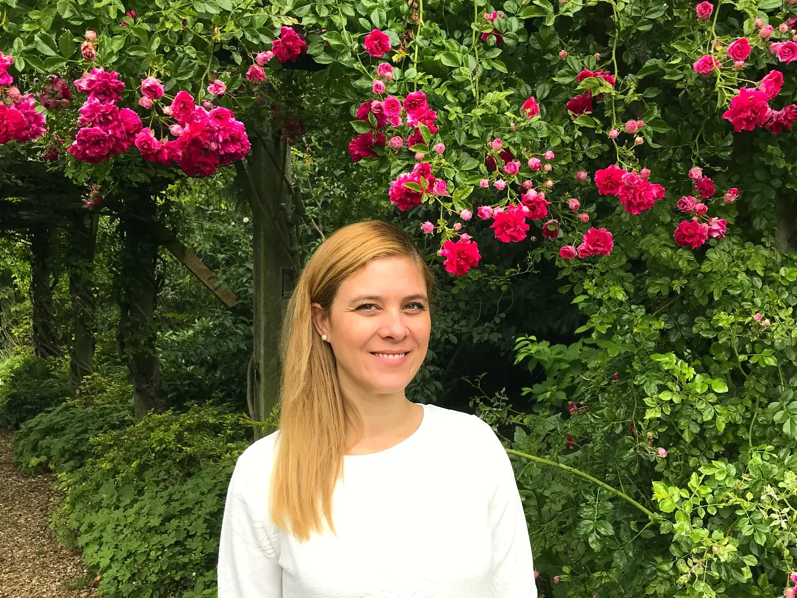 Cecilia Altieri under a pergola of climbing roses