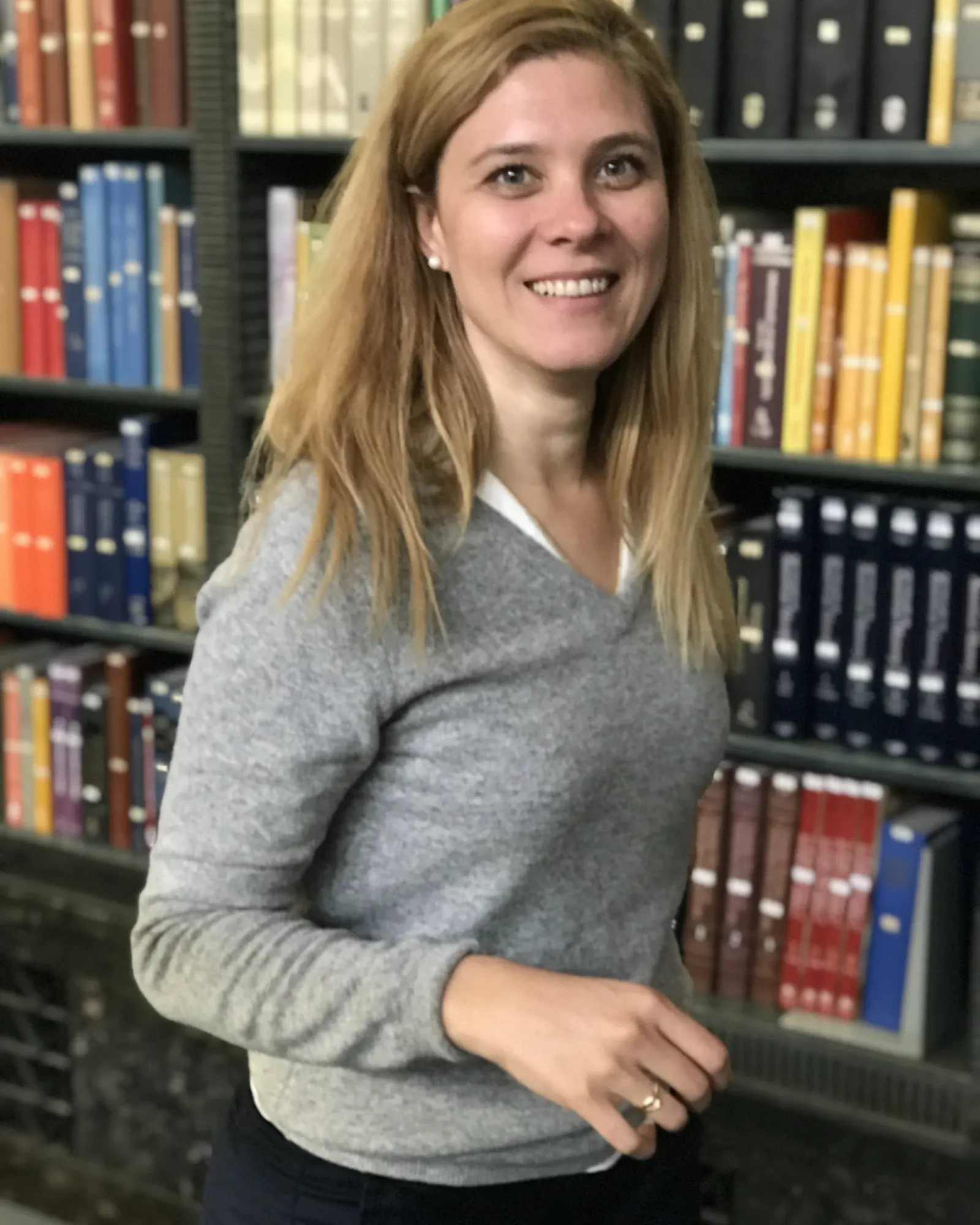 Cecilia Altieri en una biblioteca, con estanterías de libros detrás
