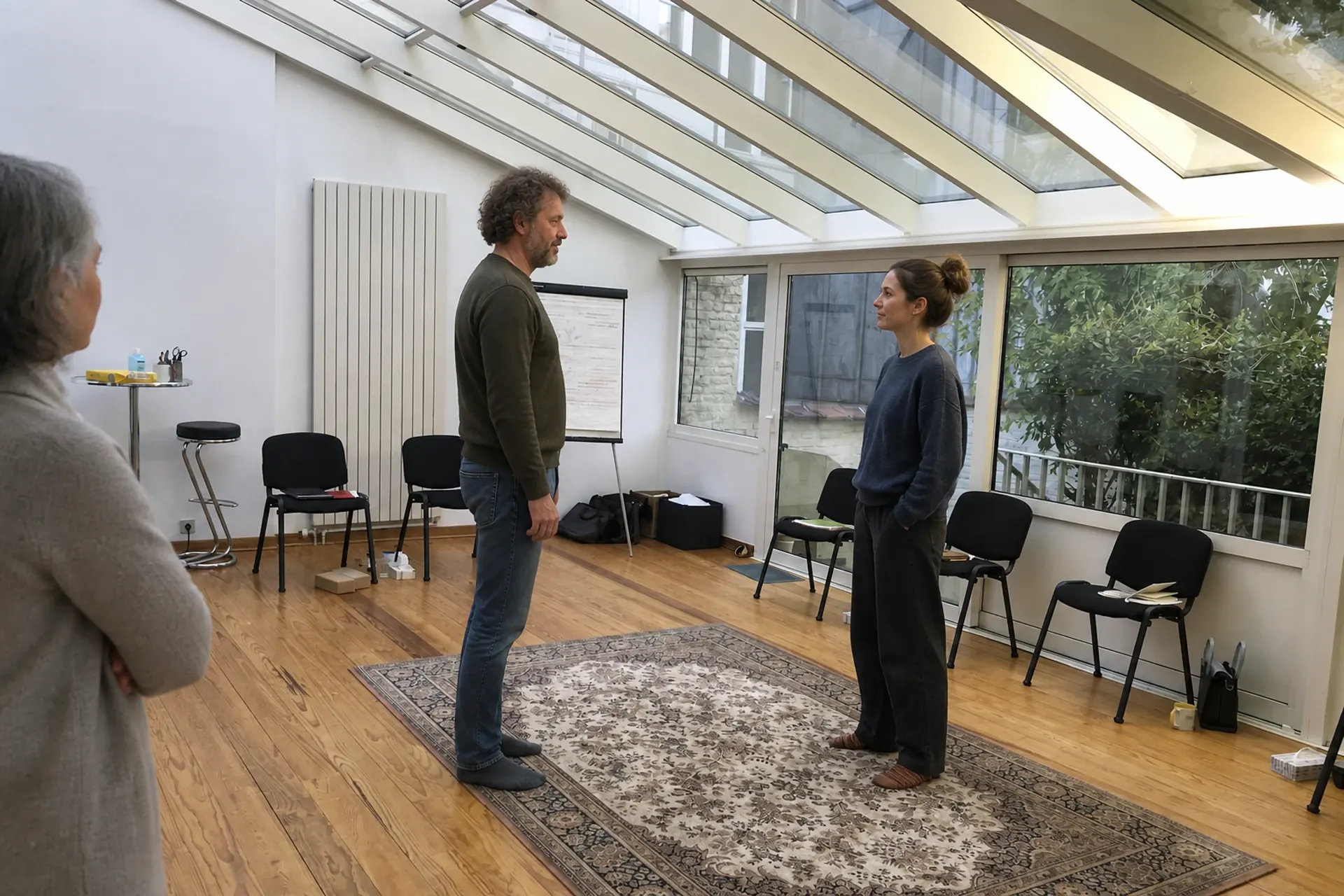 Tres personas de pie, juntas y en silencio, en el porche del taller, después de haber trabajado algo difícil